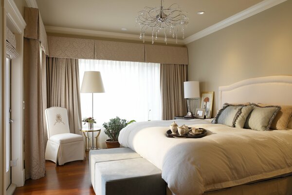 Piękna sypialnia z zasłonami i wspaniałym żyrandolem