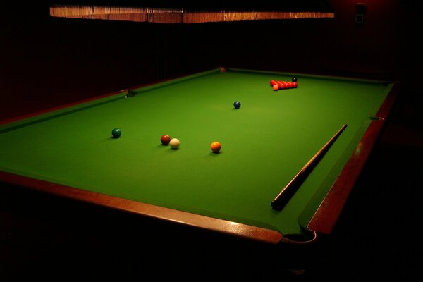 Billiard table with balls and cue