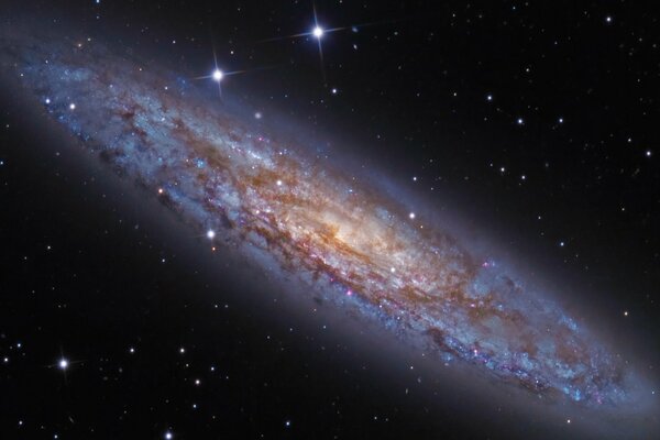 A glowing blue galaxy with stars on a black background of space