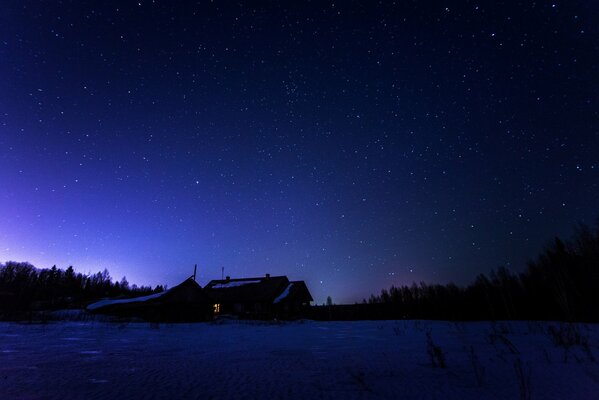 Cielo estrellado en invierno sobre una casa solitaria