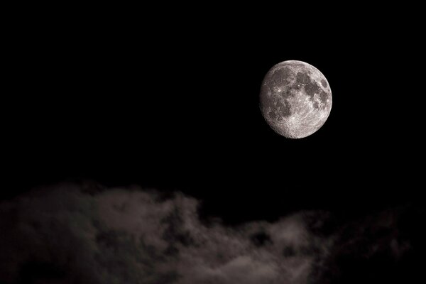 Luna su sfondo nero e nuvole galleggianti