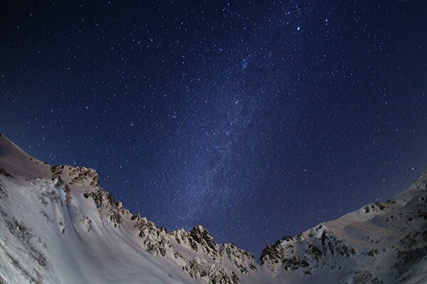 La vía láctea en las montañas cubiertas de nieve