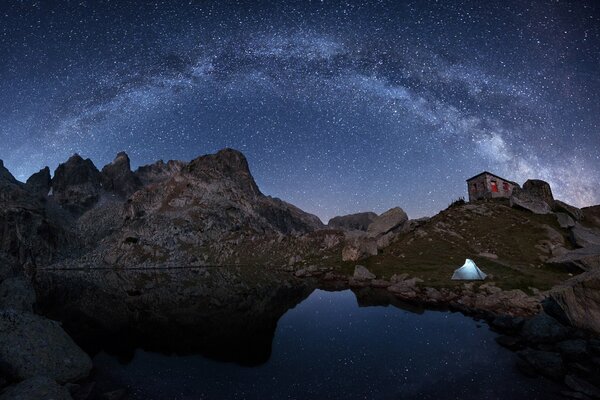 Beautiful reflection of the Milky Way in the lake against the background of mountains