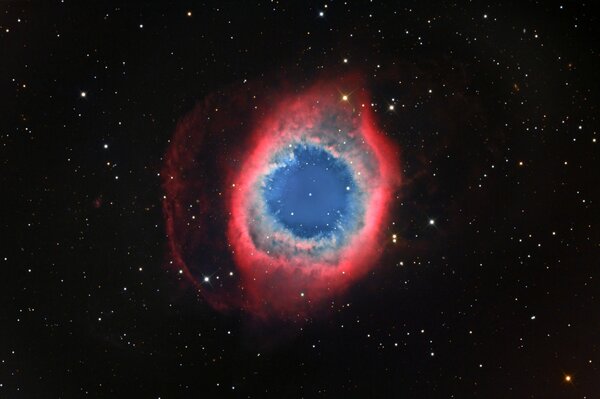 Nébuleuse rouge escargot avec bleu et vert en contour sur l espace stellaire noir