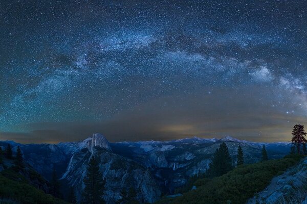 Ciel étoilé au-dessus des arbres et des montagnes