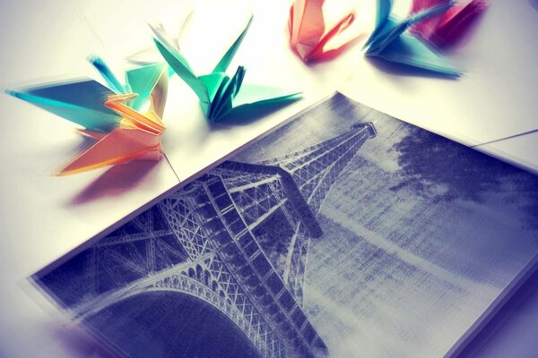 Origami cranes next to a photo of the Eiffel Tower