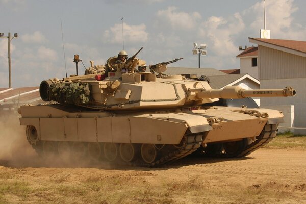 American armored vehicles Abrams tank with a tankman on a tower in sandy landscapes