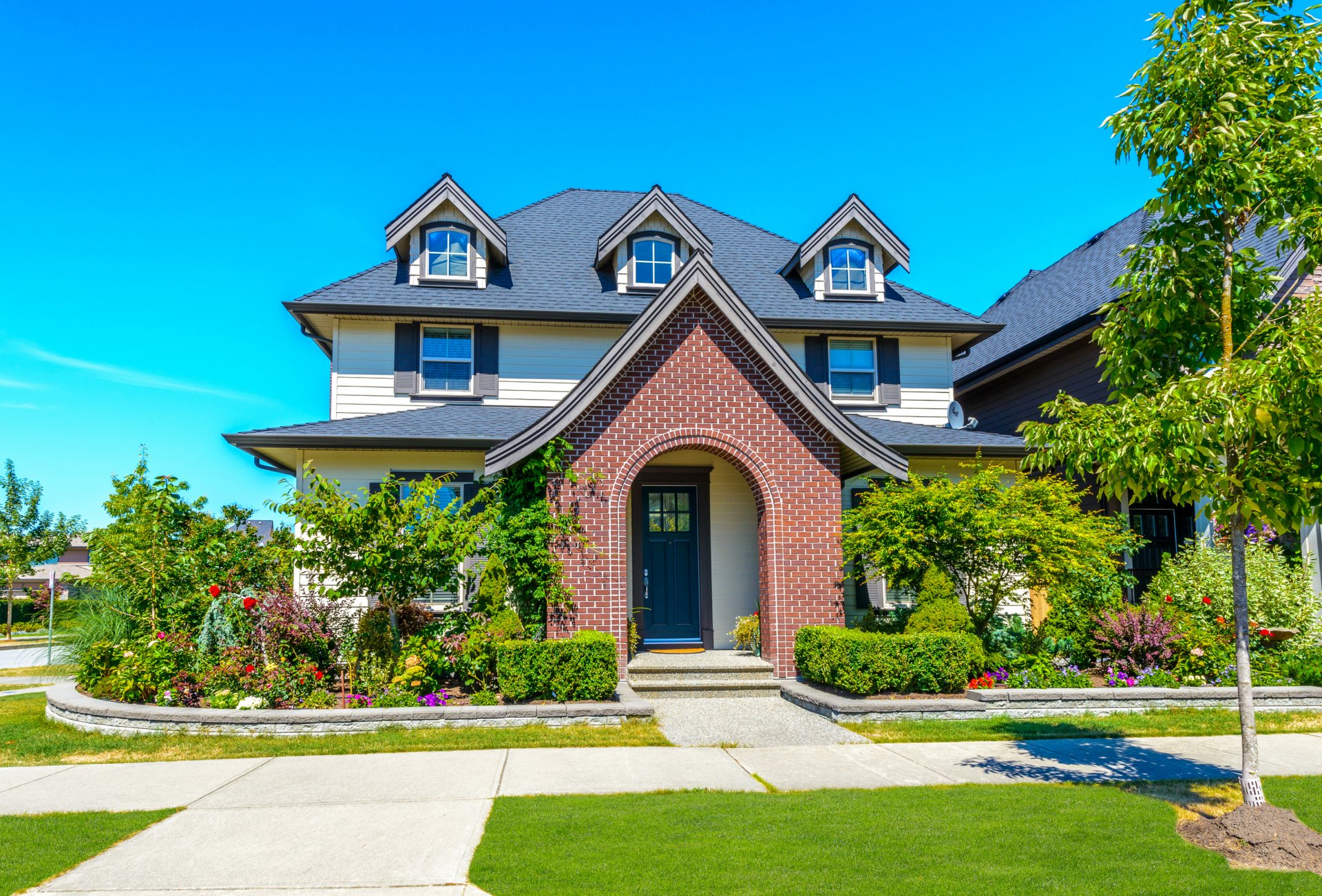 casa palazzo design prato cespugli fiori verde erba marciapiede sole cielo blu