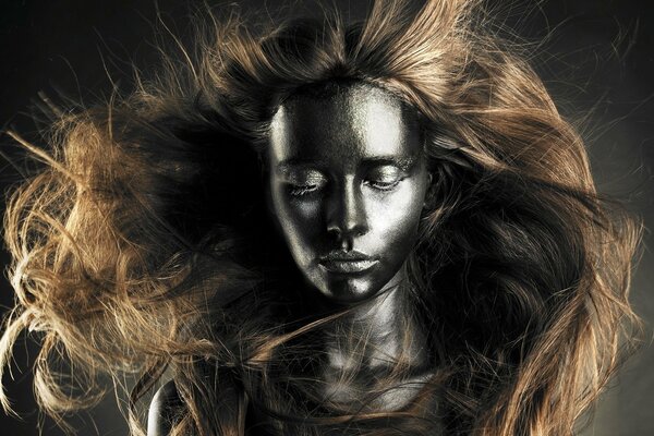 A model in paint with hair in the wind