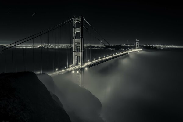 Die Nachtbrücke liegt im Nebel. Lichter der Nachtstadt