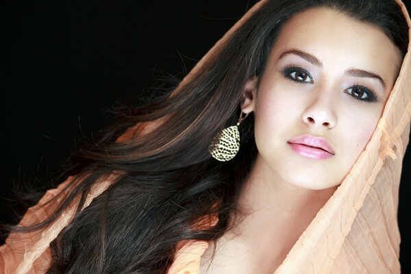 Jeune asiatique dans un foulard et de grandes boucles d oreilles