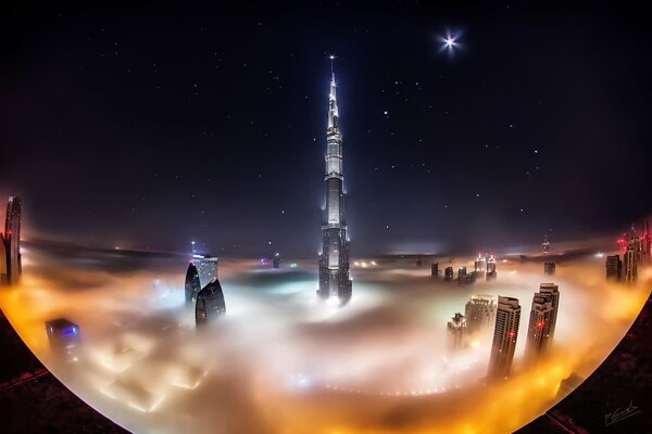 La Torre del Burj Khalifa è avvolta dalle nuvole. Cielo stellato sopra Dubai