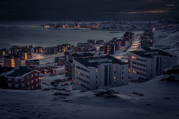 Città serale innevata sulla baia
