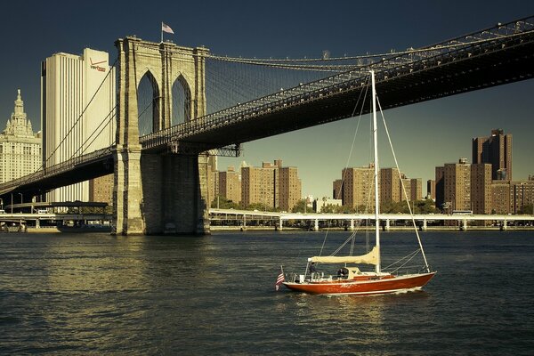 Barco navegando bajo el puente de Brooklyn