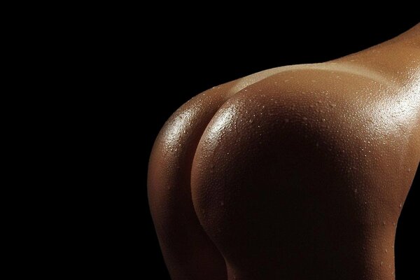 Desnudo bronceado culo sobre fondo negro