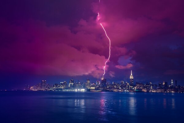 Manhattan at night, thunderstorm and lightning over the river