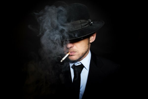 Un uomo vestito, cappello, con una sigaretta