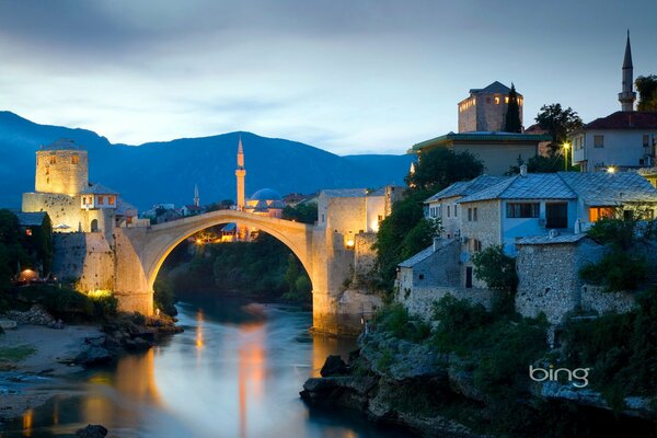 Minareto serale illuminato dal sole al tramonto. Ponte. Bosnia