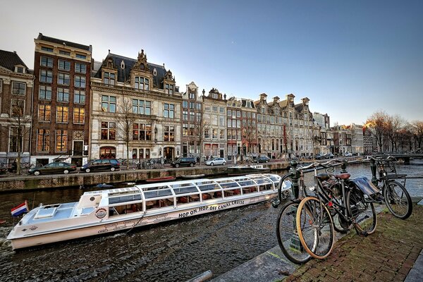 Amsterdamer Fahrräder auf Pflastersteinen am Fluss