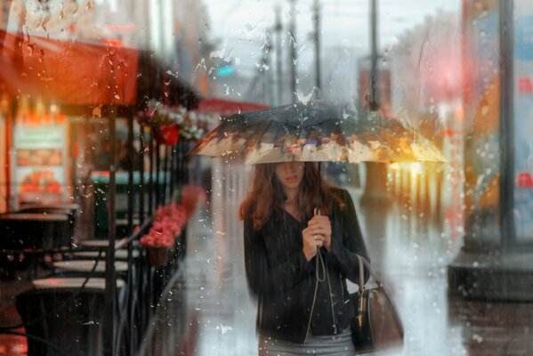 Fille sous le parapluie sous la pluie d été à Saint-Pétersbourg