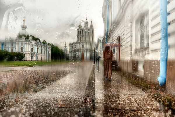 Fille dans un long manteau sous un parapluie à Saint-Pétersbourg