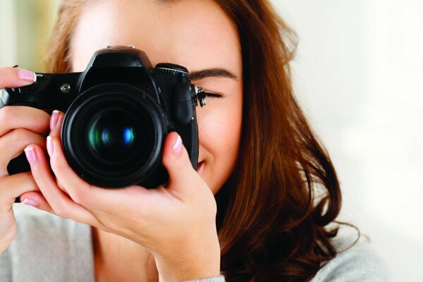 Ragazza fotografo guarda nella lente