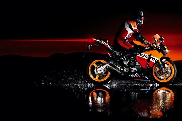 Motorcyclist on a motorcycle dark background