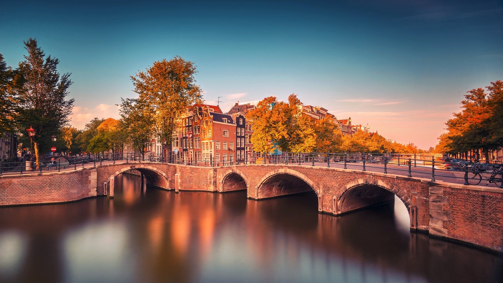 amsterdam netherlands north holland province city bridge bicycles canal river trees buildings autumn