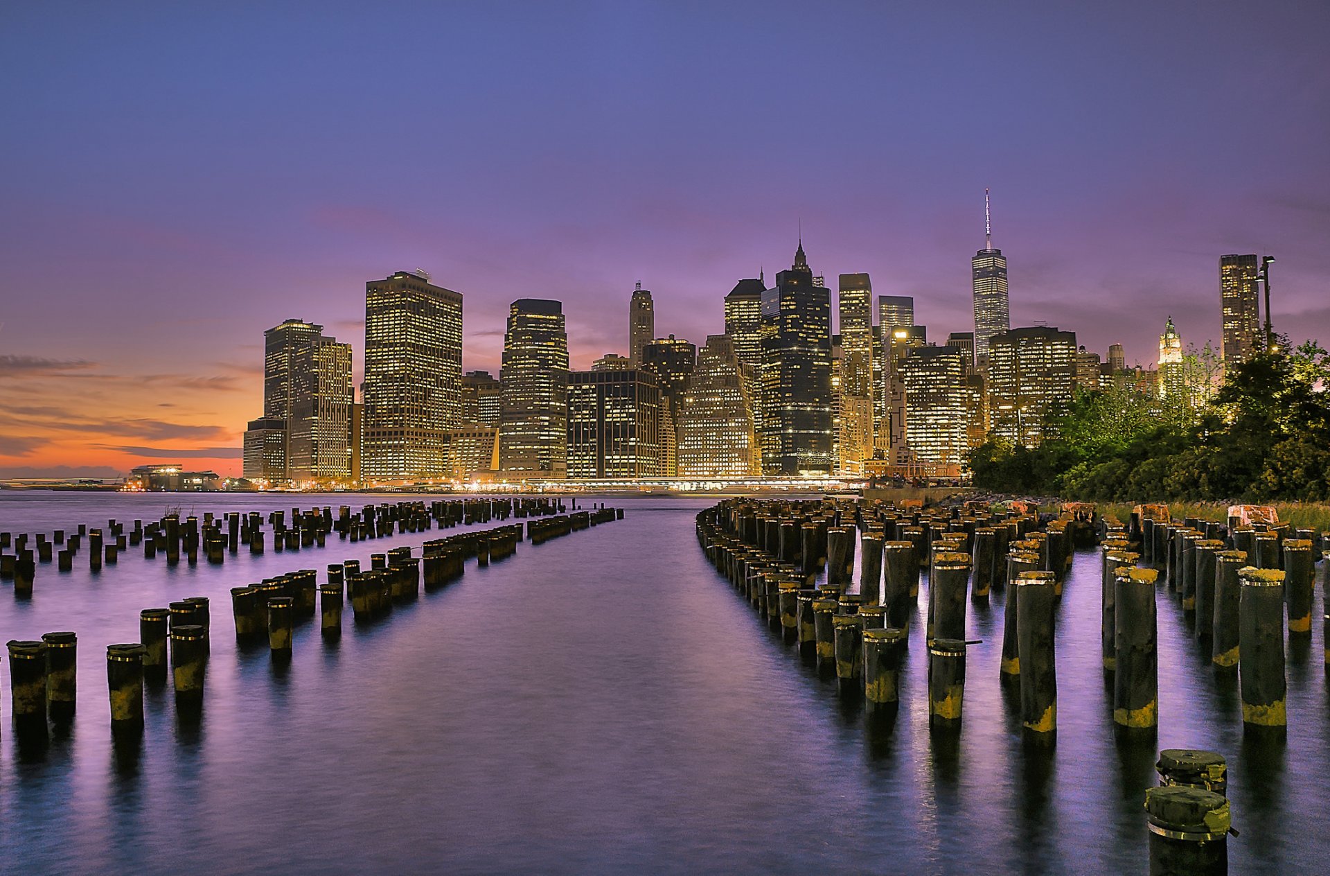 nueva york estados unidos parque del puente de brooklyn bajo manhattan east river ciudad luces rascacielos edificios río soportes costa tarde puesta de sol naranja púrpura cielo