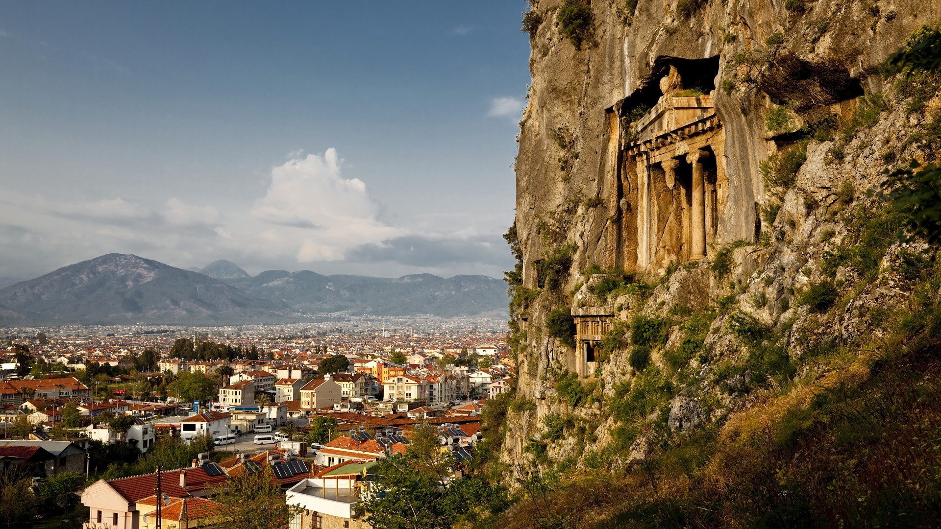 ville maisons toits vue hauteur montagnes rocher structure antique temple colonnes pierres