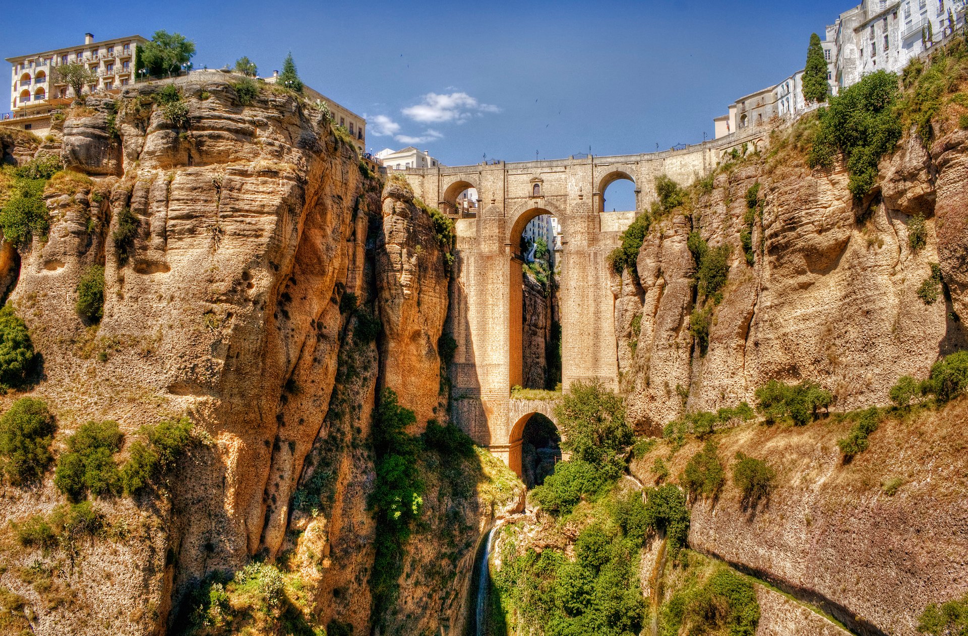 ronda andalusia spain aqueduct bridge arch rock house sky river bush