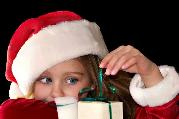 A girl in a hat unpacks a gift