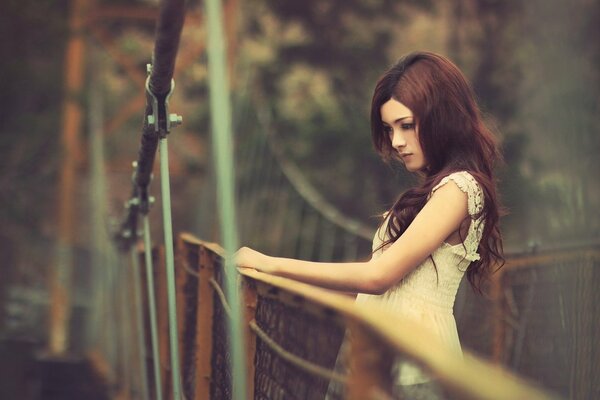 Belle fille sur le pont en regardant vers le bas