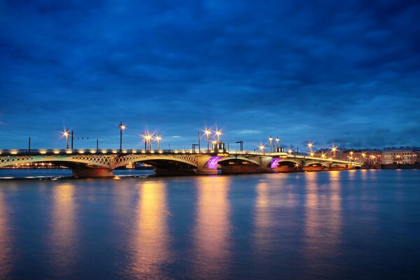 Pont lumineux sur la rivière de nuit