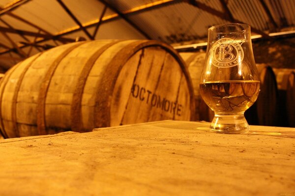 A glass of beer on the background of barrels