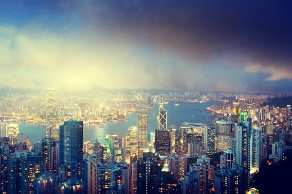 Panorama of Hong Kong - river, clouds and high-rise buildings against the night sky