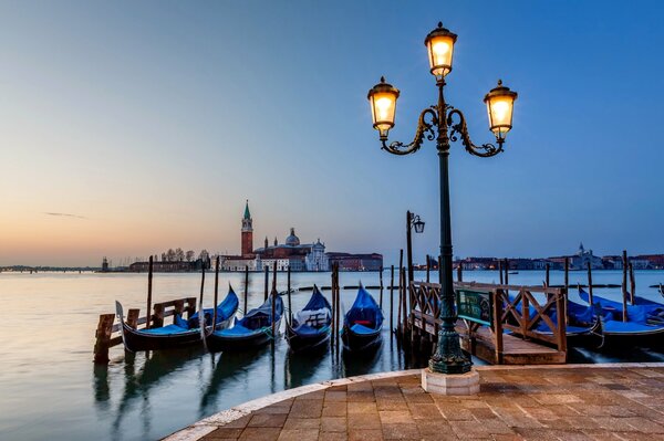 Muelle de góndolas en I Venecia por la noche