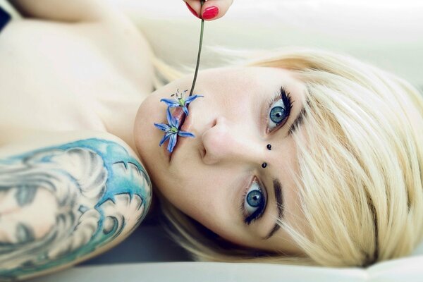 Belleza rubia en tatuajes y piercings