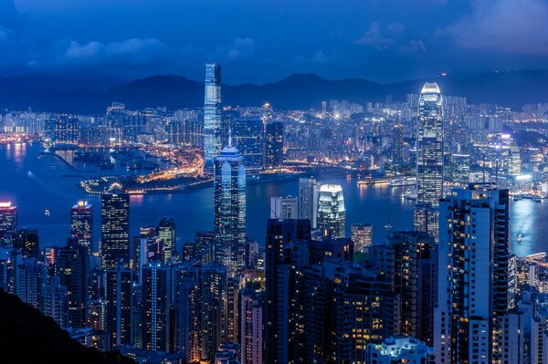 Panorama nocturno, China, Hong Kong. Puerto victoria de Hong Kong, vista de los rascacielos por la noche. Puerto victoria: vista desde arriba. Rascacielos Del Puerto De Victoria En Hong Kong. Bahía Victoria