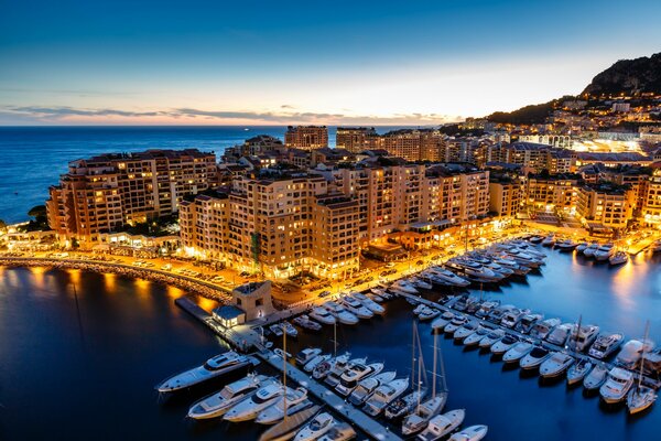 Фонвей, княжество Монако. Вечерний город на лазурном берегу, окруженный водой, на фоне гор