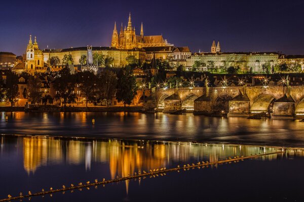 Nocne miasto Praga odbija się w Wełtawie