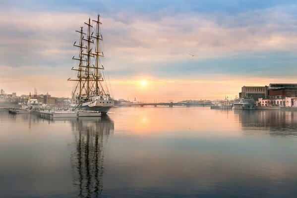 Barco con velas desinfladas al amanecer