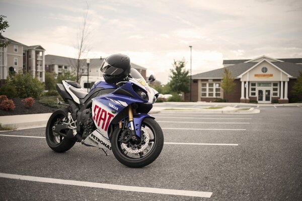 White and blue bike with helmet in the parking lot