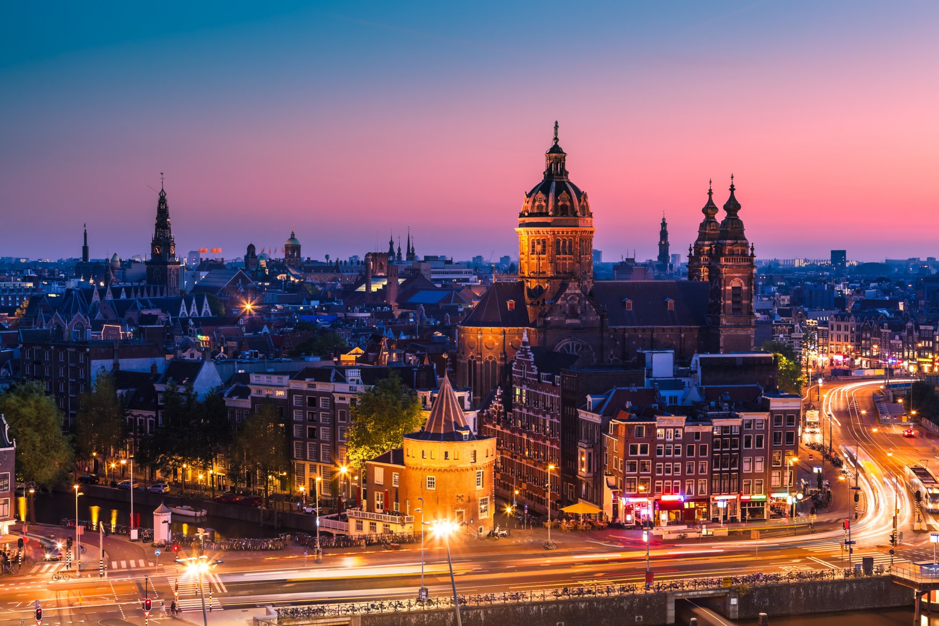 amsterdam nord-holland niederlande stadt abend sonnenuntergang häuser gebäude dächer straßen autos straßen lichter belichtung