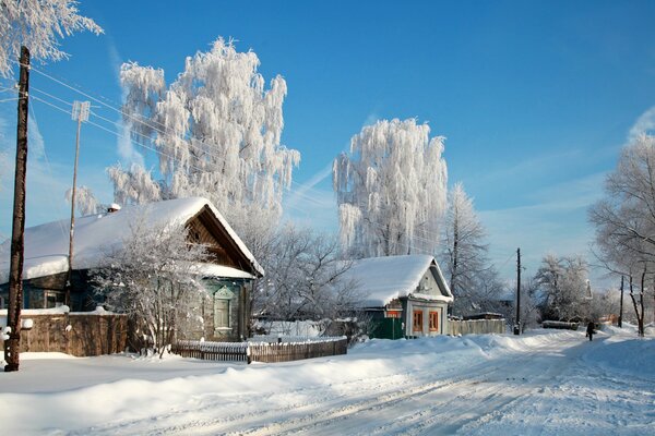 Vecchie case di capanna nella neve nella città di Russia