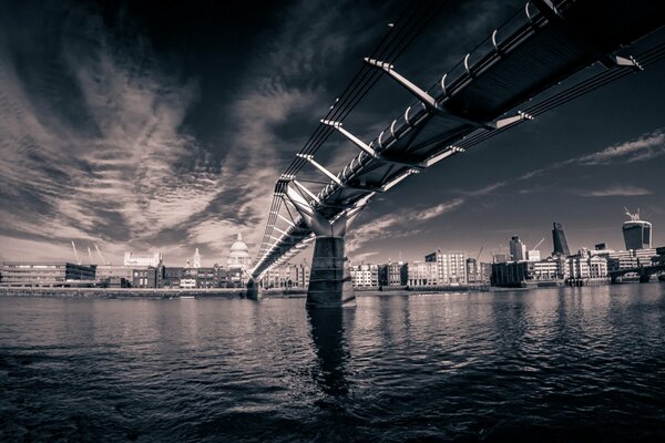 Black and white image of a bridge over dark water