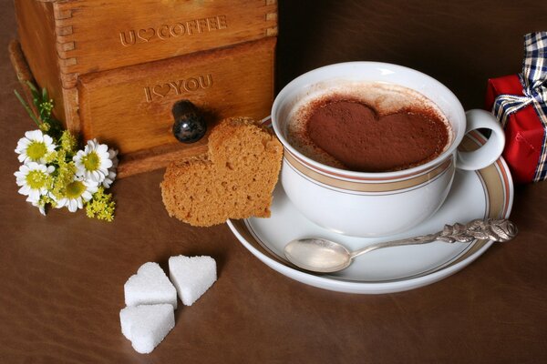 Café caliente en una taza con una pizca de chocolate en forma de corazón