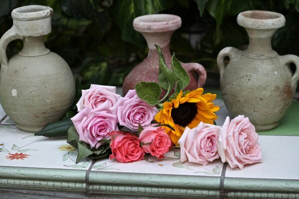 Rosa Rosen und Sonnenblumen auf Vasen Hintergrund