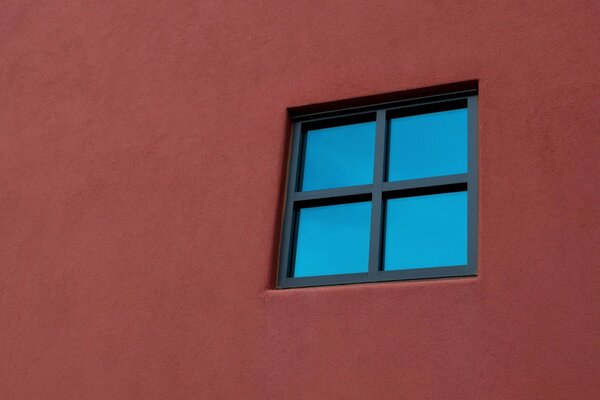Fenêtre noire sur le mur rouge (minimalisme)