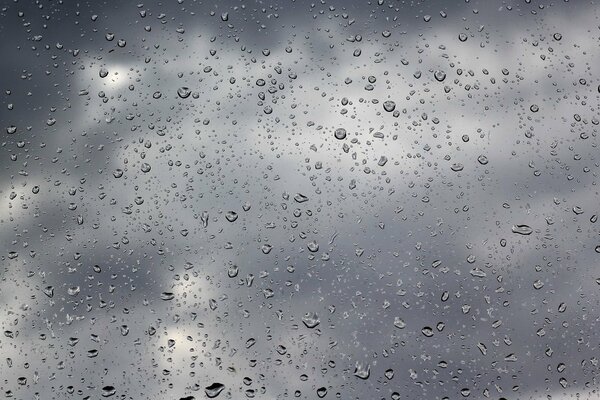 Temps nuageux et gouttes de pluie sur le verre